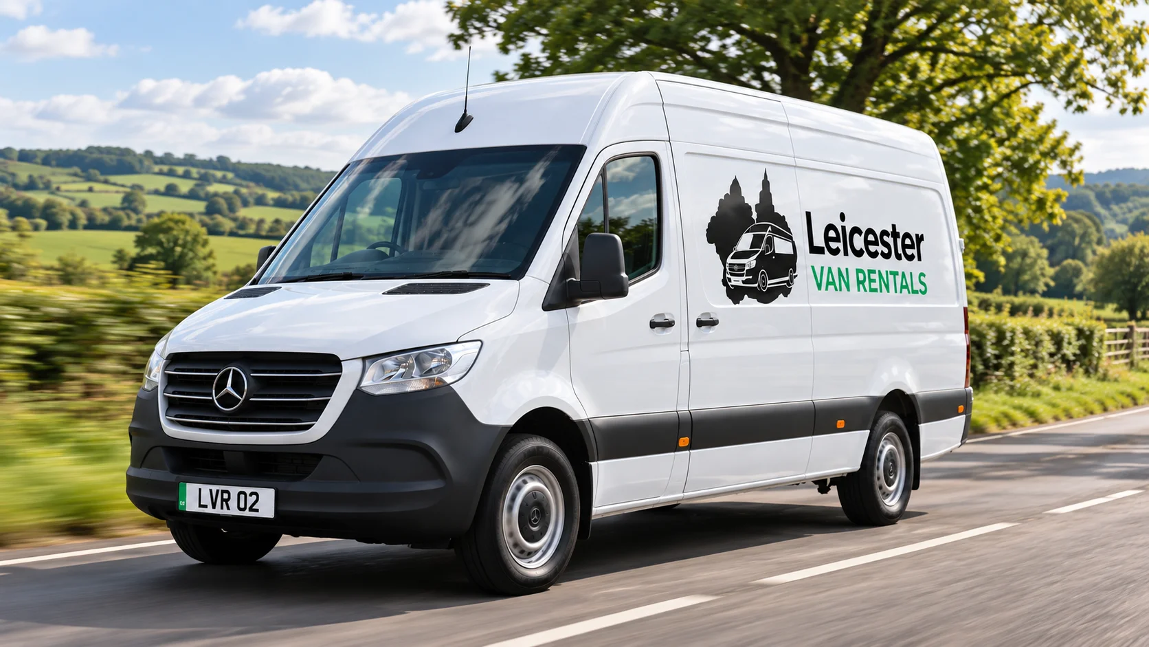 Leicester Van Rentals white Luton van driving on a scenic road surrounded by trees and countryside.