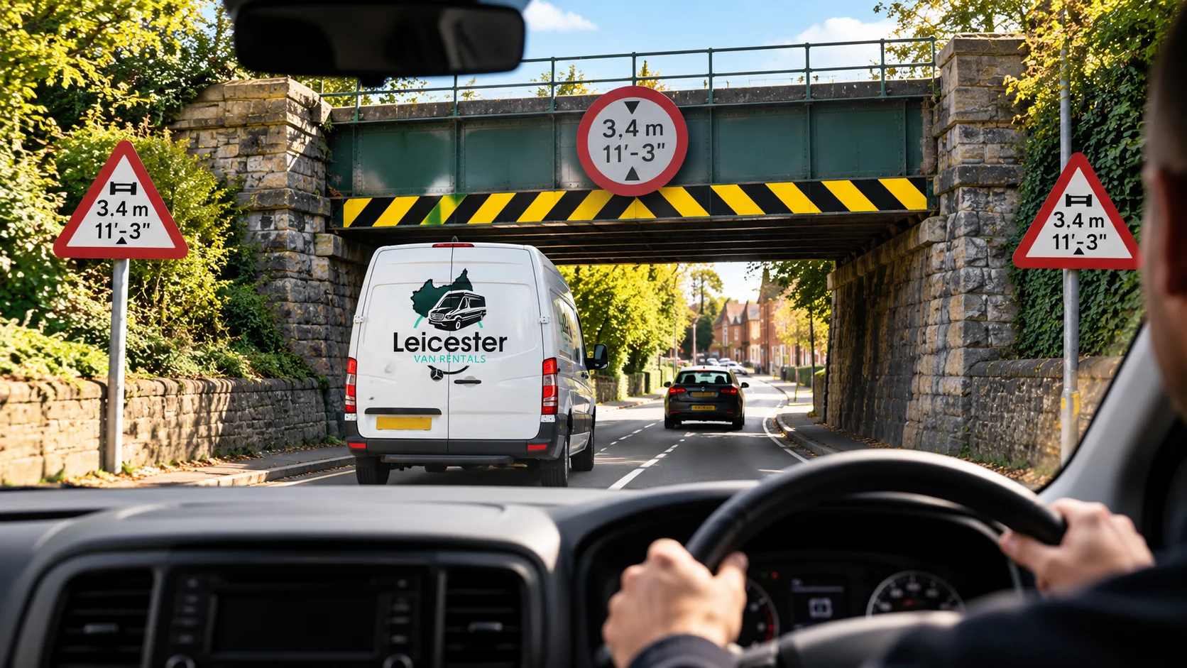 Leicester Van Rentals van approaching a low bridge with a vehicle height restriction sign.
